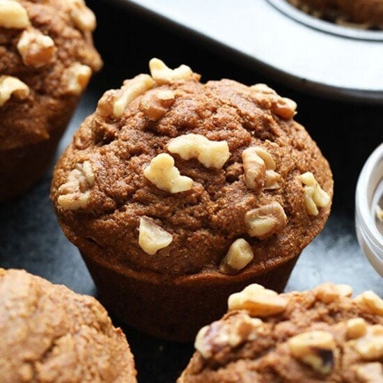pumpkin muffins with walnuts on a tray.