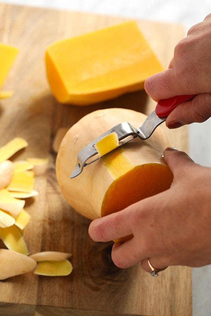 Peeling butternut squash with a vegetable peeler