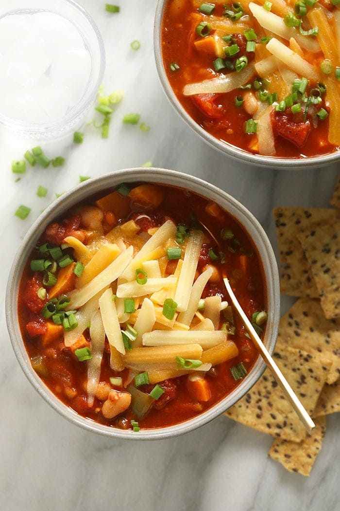Vegetarian Chili so tasty you won't even know it's meatless. This vegetarian chili recipe is made with beans, sweet potato, diced tomatoes, and a delicious homemade chili seasoning. vegetarian chili in bowl with cheese