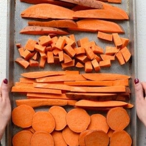 Sweet potatoes cut into a variety of shapes on a baking sheet.