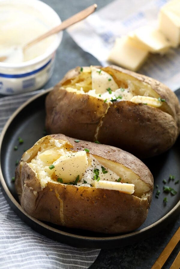 crock pot baked potatoes on a plate topped with butter