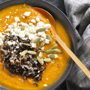 a bowl of butternut squash soup with seeds.