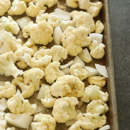 Cauliflower florets on a baking sheet, perfect for making cauliflower mashed potatoes.