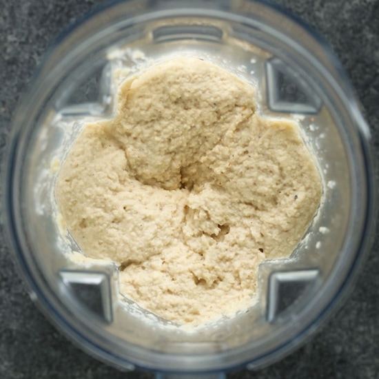 A bowl of cauliflower mashed potatoes in a food processor.