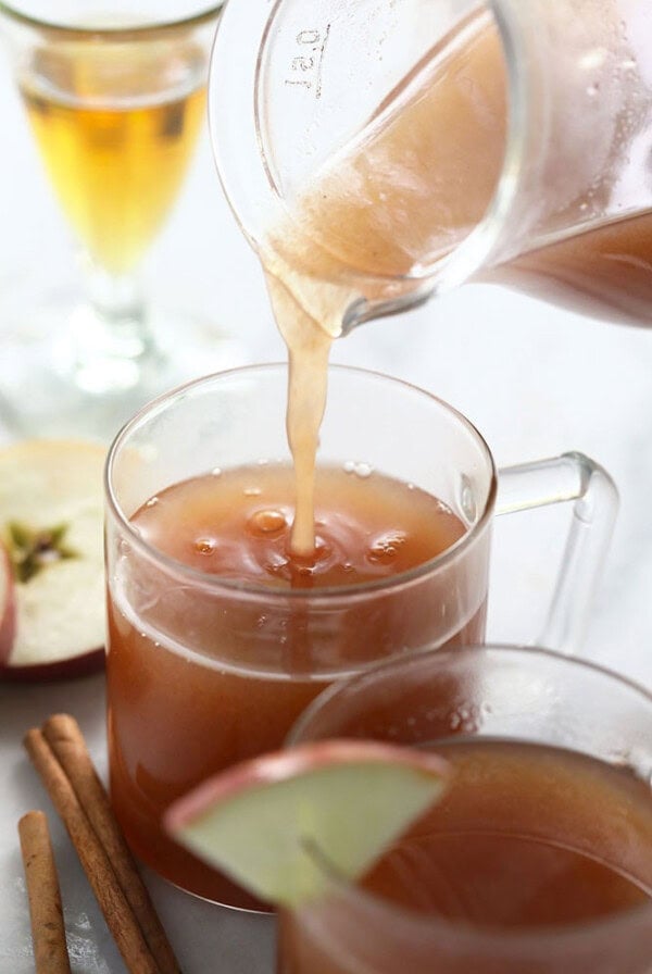 spiked apple cider being poured in a mug
