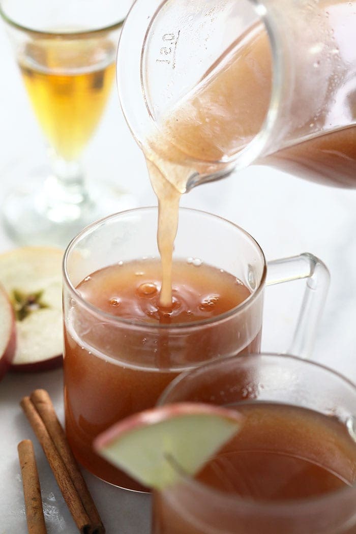 spiked apple cider being poured in a glass