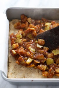 An apple pie bar baked on a baking pan, served with a spatula.