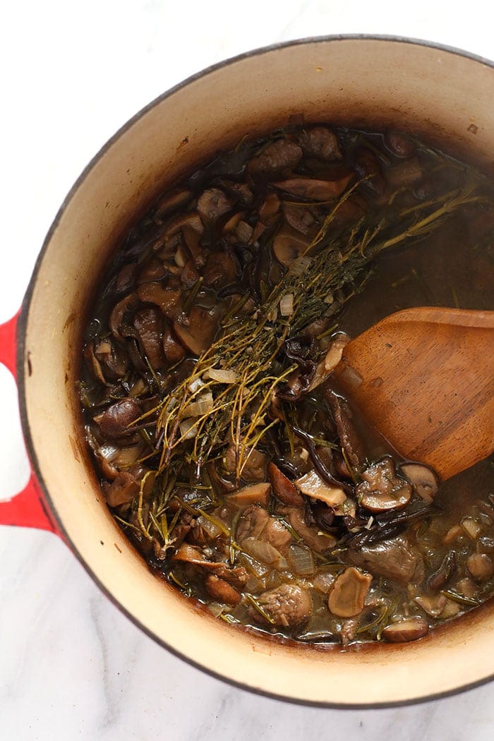 Mushroom gravy cooking down in a dutch oven.