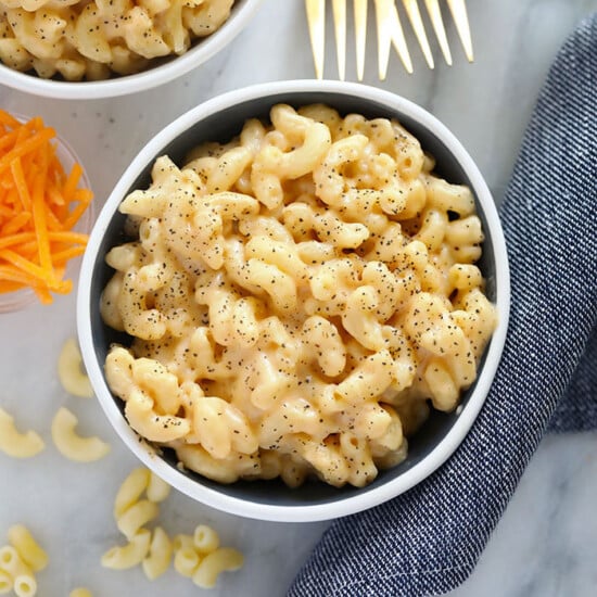 Two delectable bowls of macaroni and cheese on a sleek marble table, showcasing a savory mac and cheese recipe.