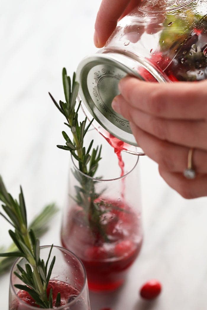 Pouring the cranberry mojito into a glass