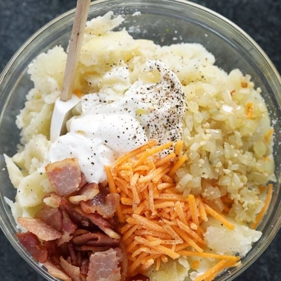 a bowl of potato salad with bacon, cheese and sour cream inspired by twice baked potatoes.