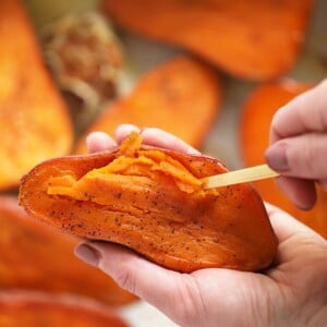 a person holding mashed sweet potatoes in their hand.