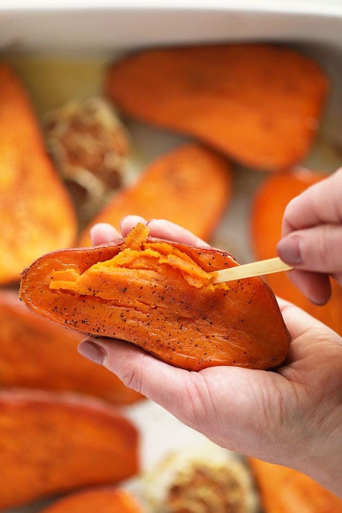 scooping out sweet potato flesh with spoon