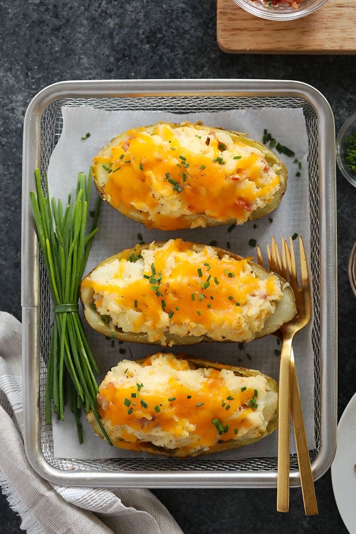 Twice baked potatoes are the ultimate dinner idea. They're made with perfectly crispy potato skins and the most delicious cheesy filling. twice baked potatoes ready to be served