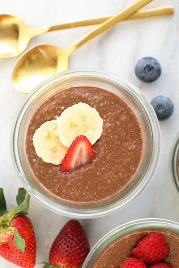 Three protein chia seed pudding bowls with berries and bananas.