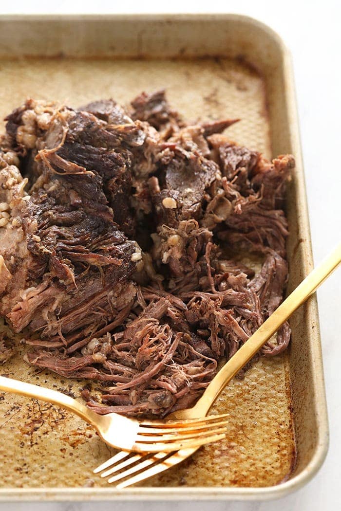 Shredded chuck roast on a baking sheet.