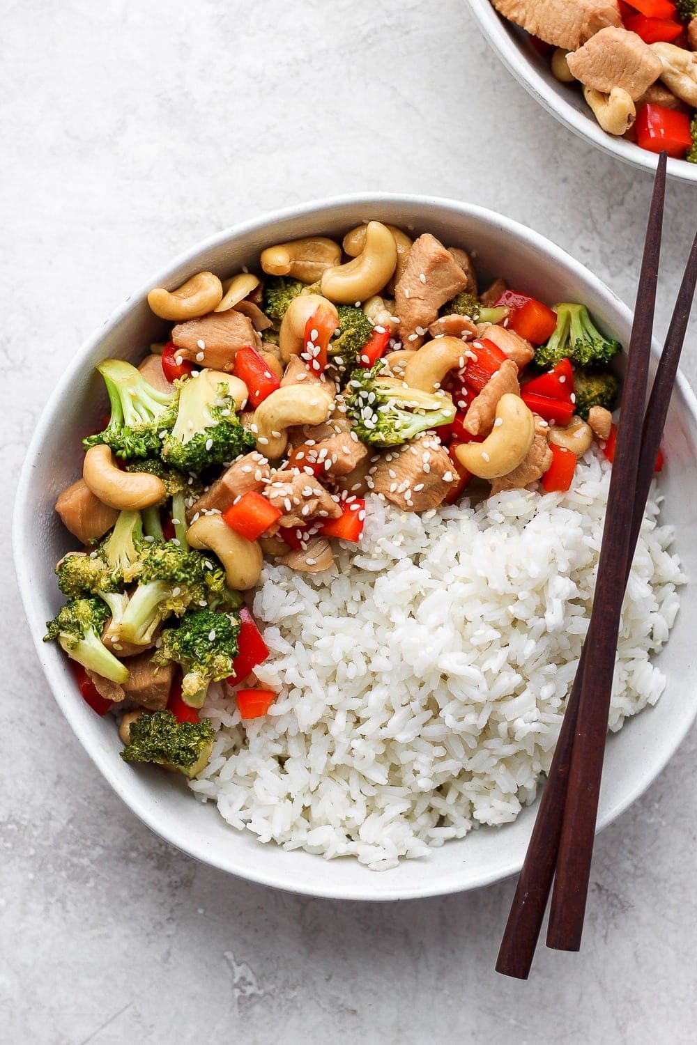 instant pot cashew chicken in a bowl with rice and chopsticks