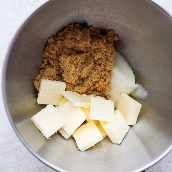 A mixing bowl with butter, sugar, and flour for gingersnap cookies.