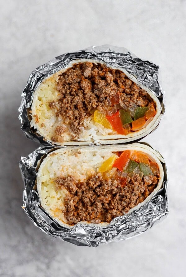 a frozen burrito wrapped in foil with meat and vegetables.