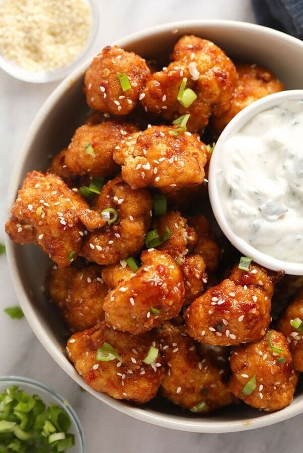 a bowl of cauliflower wings with a dipping sauce.