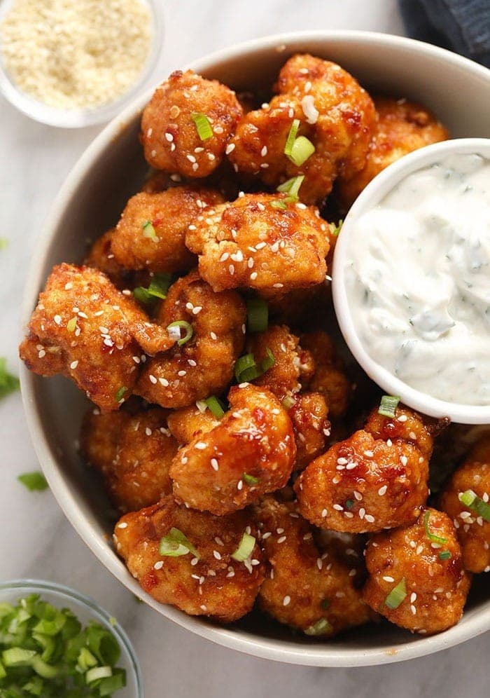 a bowl of cauliflower wings with a dipping sauce.