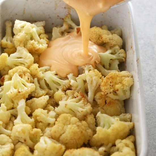 A cauliflower dish with a cheesy sauce poured over it.