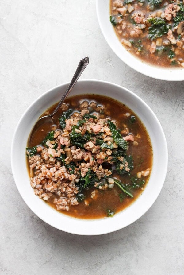 Bowl with two soups featuring meat and kale.
