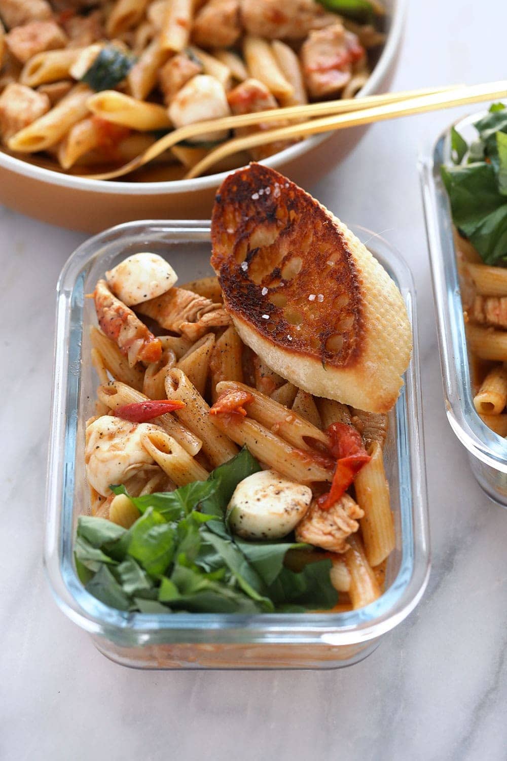 pasta de pollo caprese saludable en un recipiente de preparación de comidas