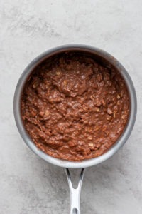 Chocolate batter in a pan on a white surface, made with protein oatmeal.