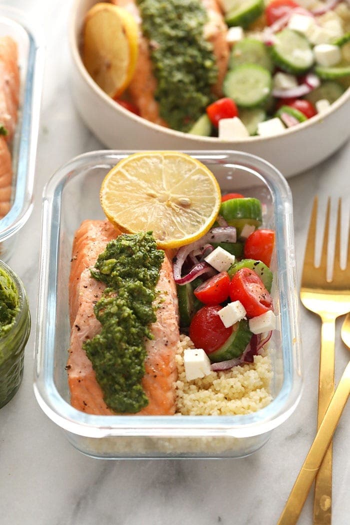 Meal prep lunch box containers with baked salmon fish, rice, green