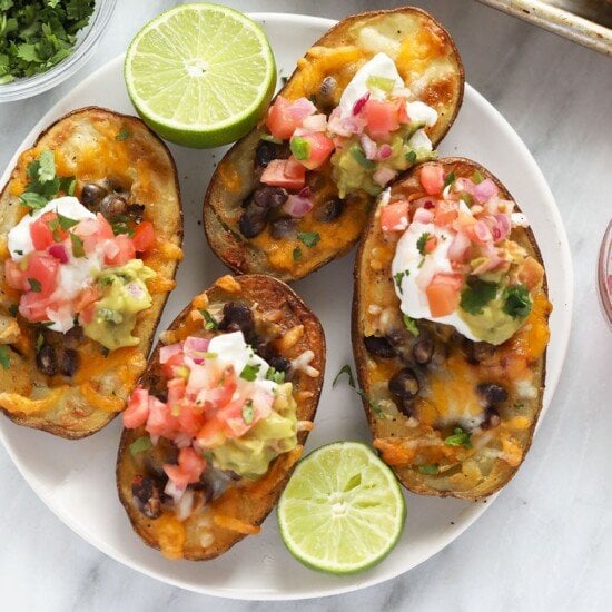 Mexican potato skins with guacamole and sour cream on a plate.