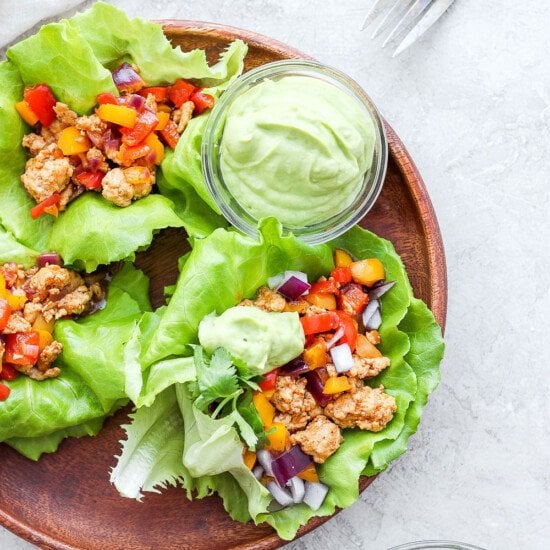 Chicken lettuce wraps with guacamole on a plate.