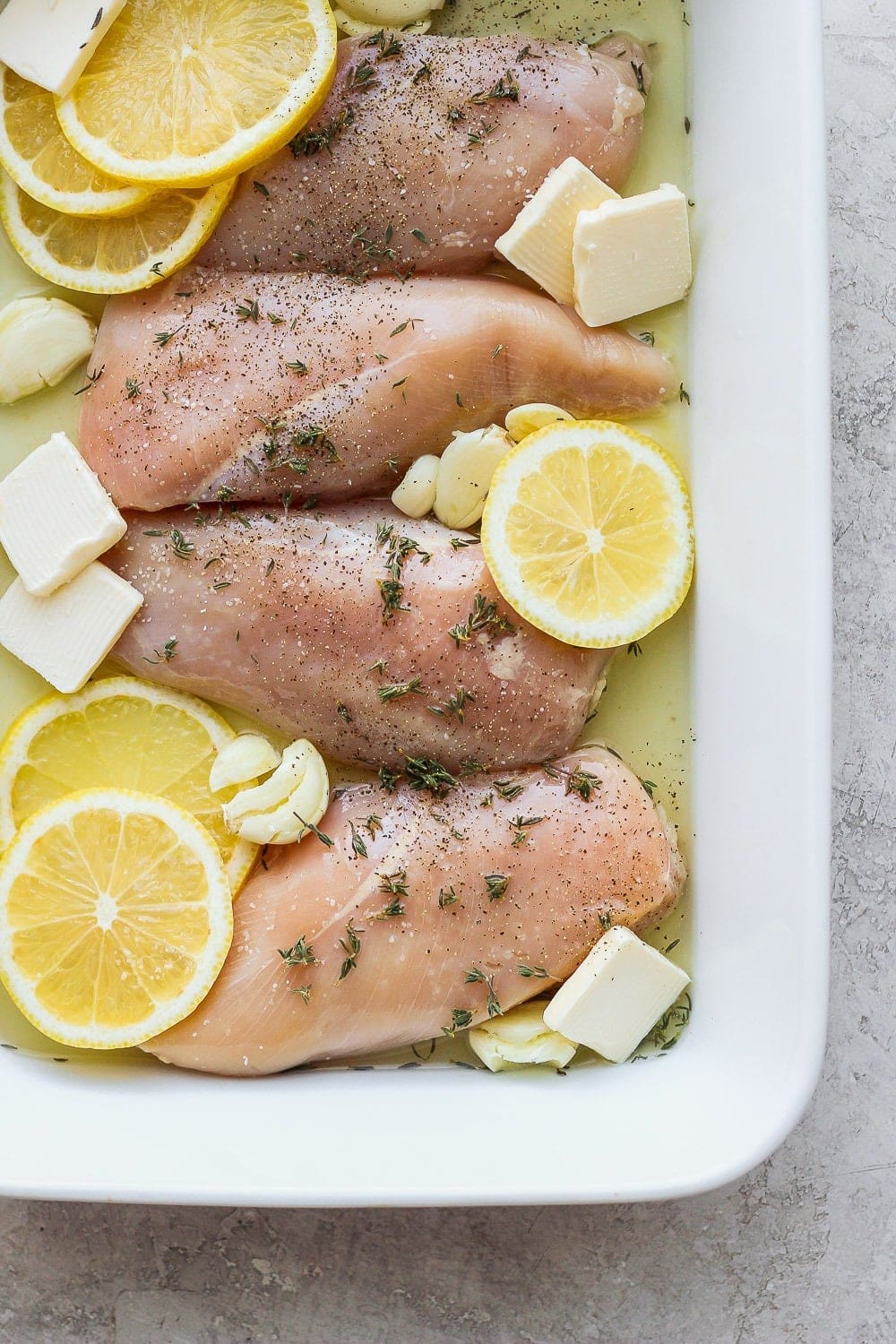 raw chicken with lemon, garlic, and ،er