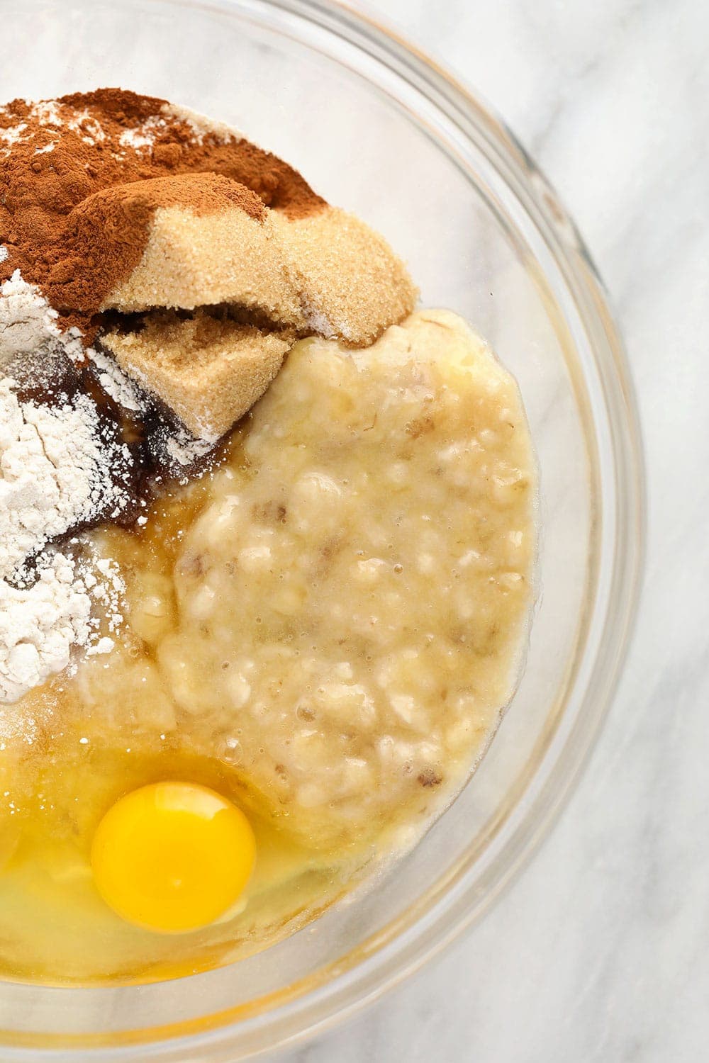 mashed banana and muffin ingredients in bowl