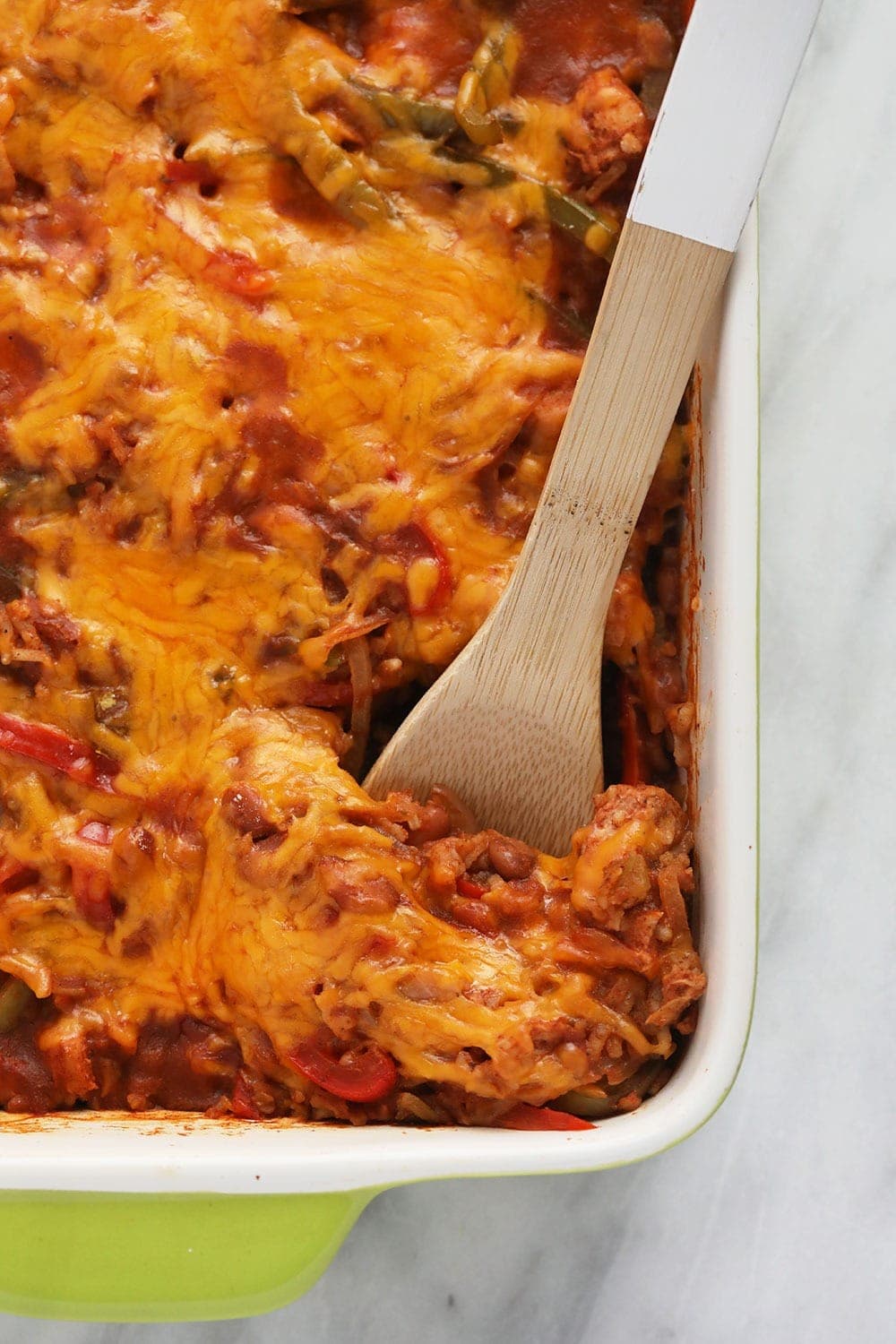 chicken burrito bowl casserole being scooped out of a casserole dish with a serving spoon