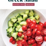 Greek salad with tomatoes and cucumbers, served in a white bowl.