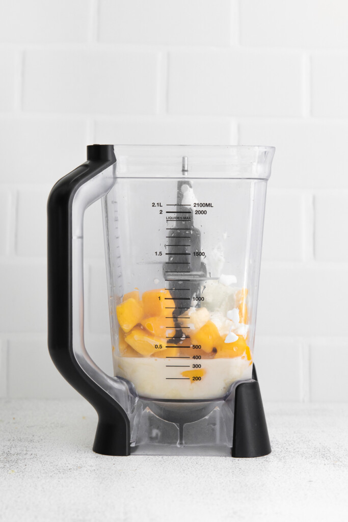 Frozen mango and other ingredients in a high speed blender. 