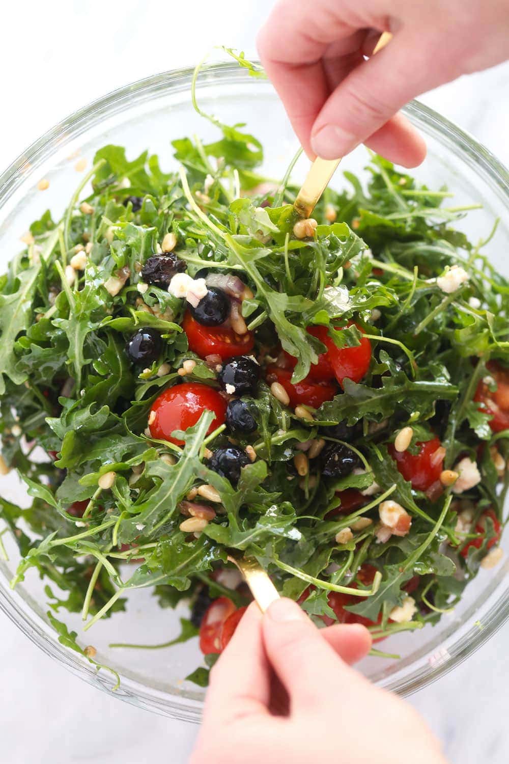 Arugula salad in a mixing bowl. 