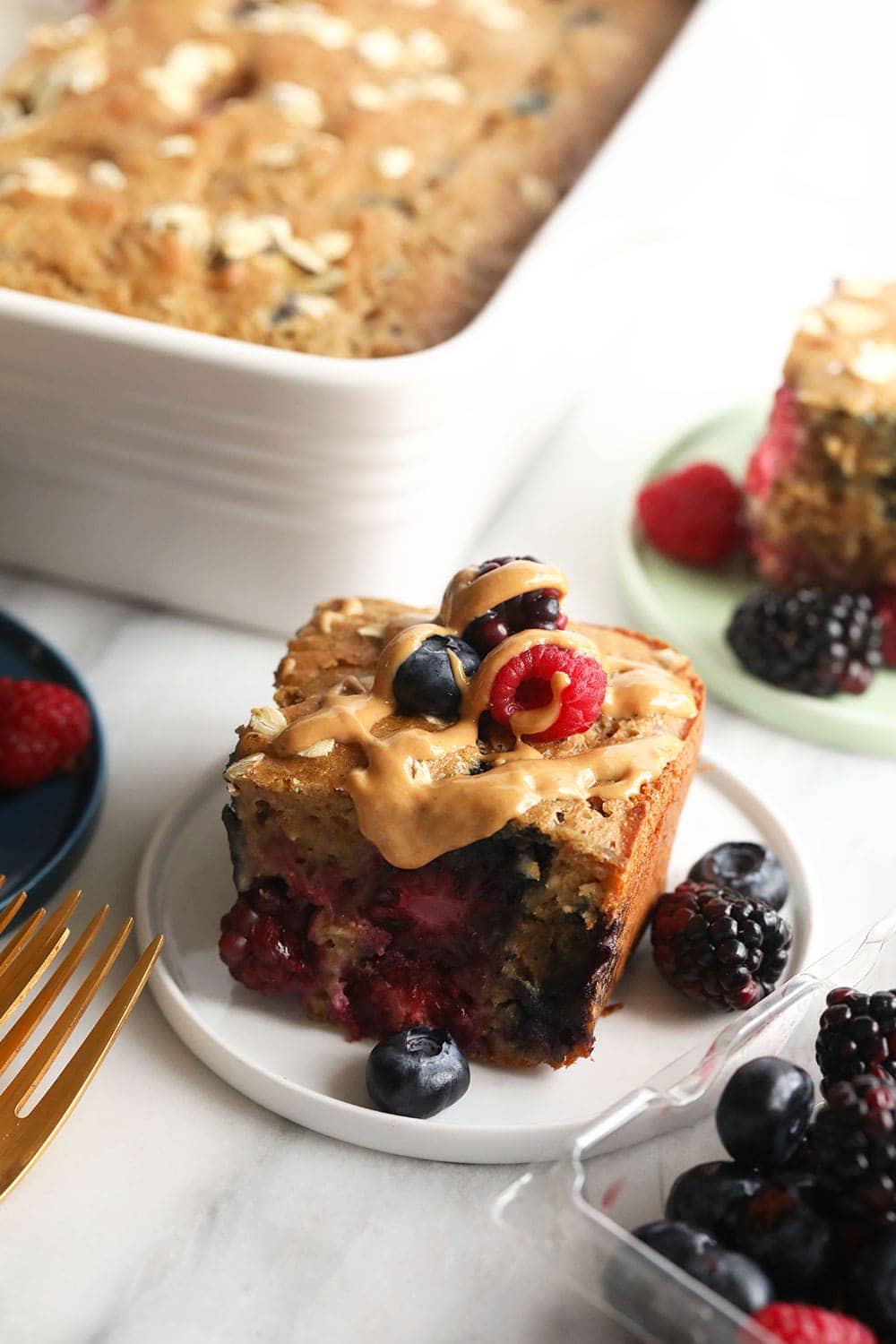 This triple berry breakfast bread is a moist, perfect for a quick morning breakfast, and it is so easy to make! Make a pan of this breakfast bread and top it with your favorite nut butter or Greek yogurt! Triple Berry Breakfast Bread on a Plate.