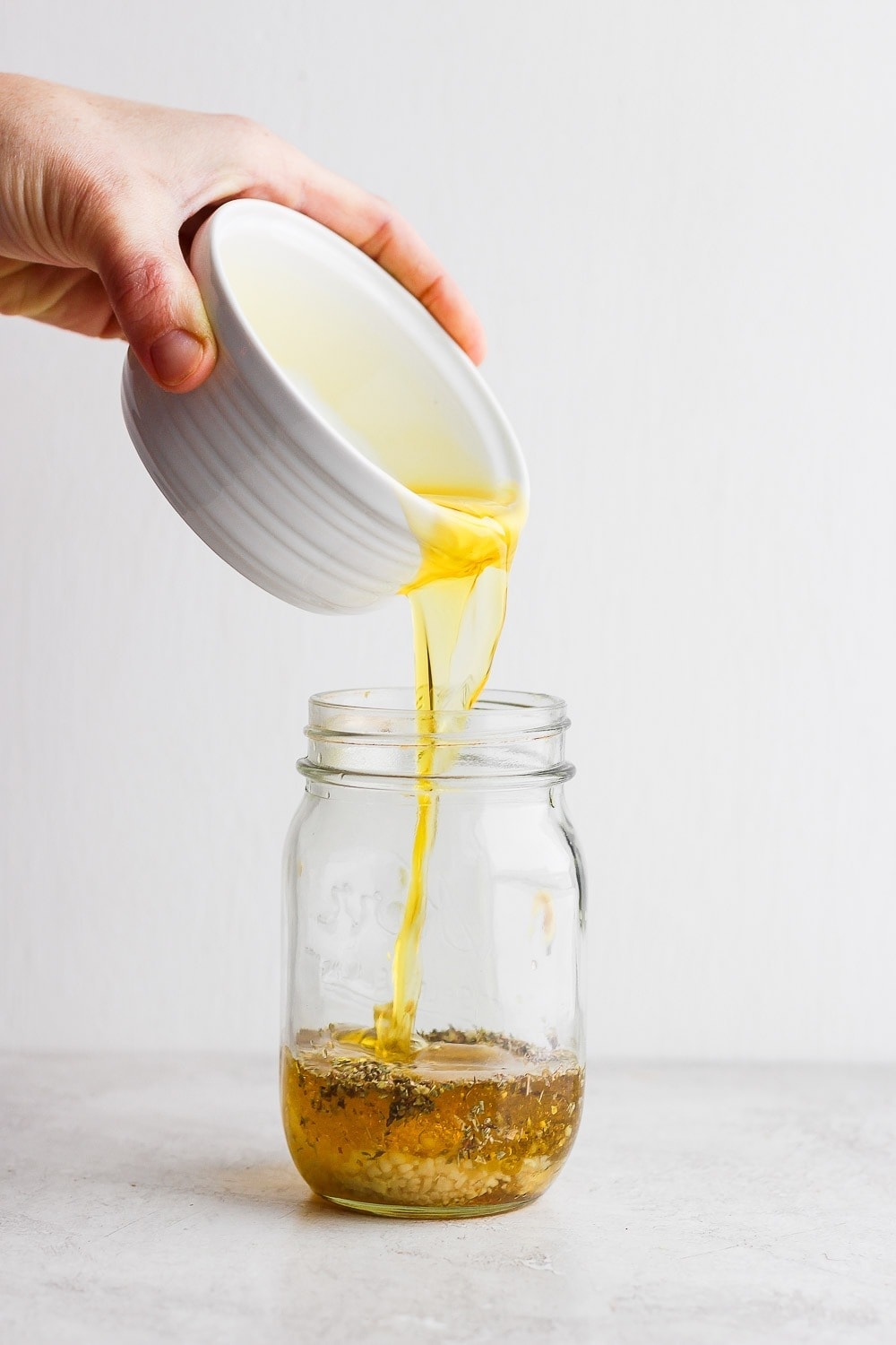 Pouring olive oil into a mason jar