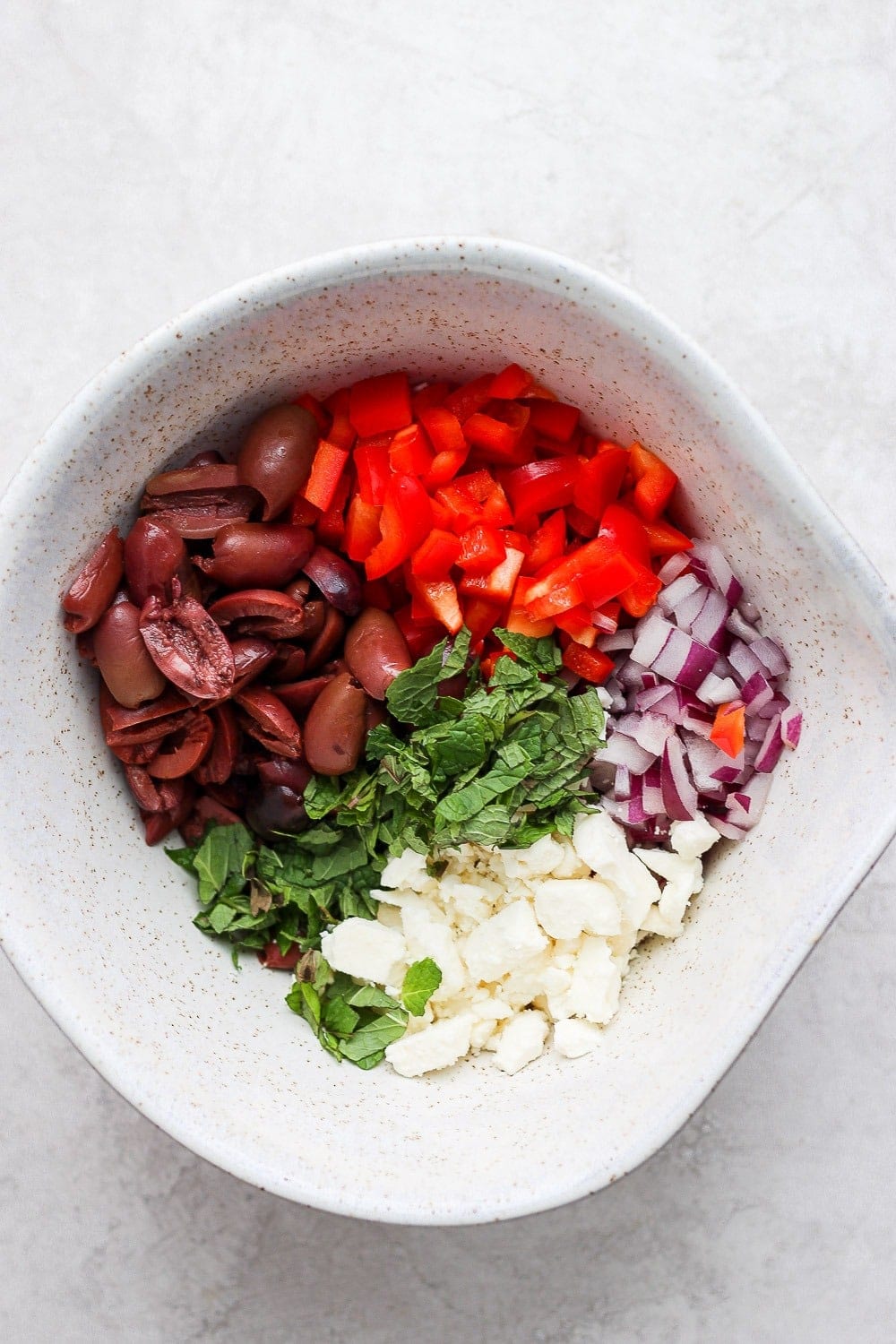 Ingredients for the greek salad in a large bowl