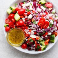Greek salad recipe with tomatoes, cucumbers, and onions.