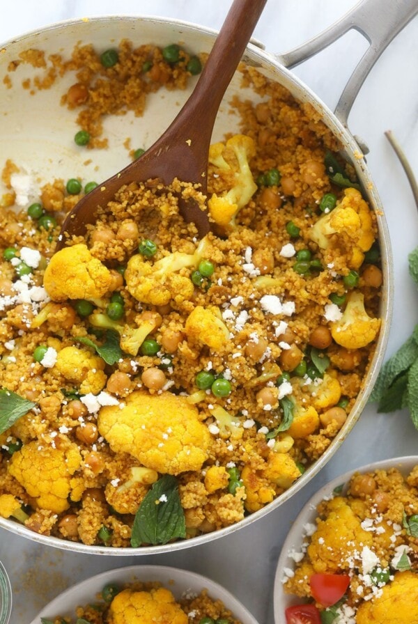 moroccan chickpea couscous in a skillet topped with feta cheese