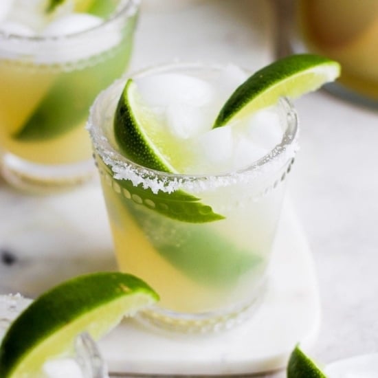 Skinny margaritas garnished with lime wedges on a white plate.