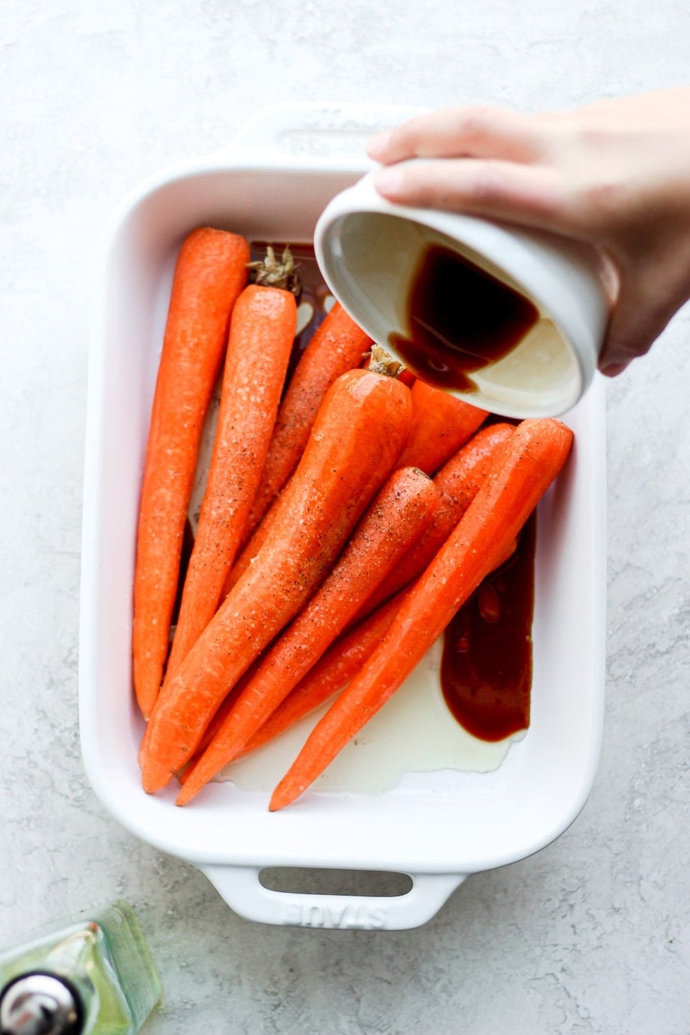 Pouring marinade over the carrots.