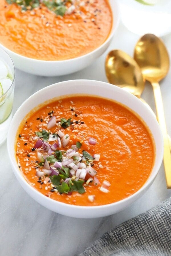 instant pot sweet potato carrot ginger soup in a bowl topped with cilantro and red onion