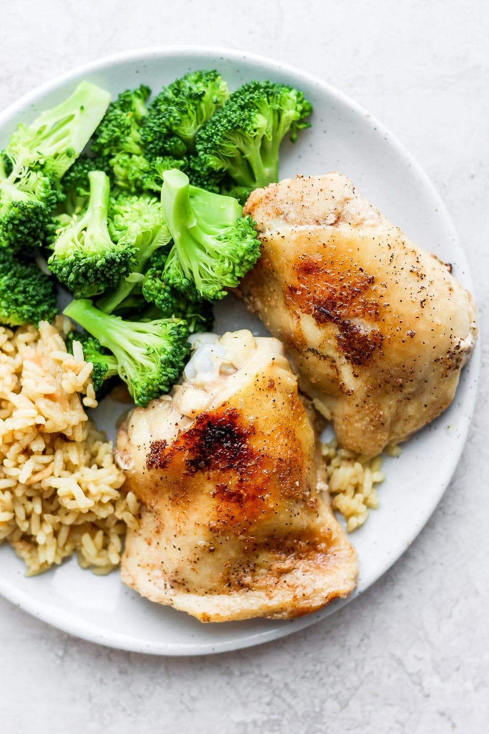 chicken thighs on plate with rice and broccoli