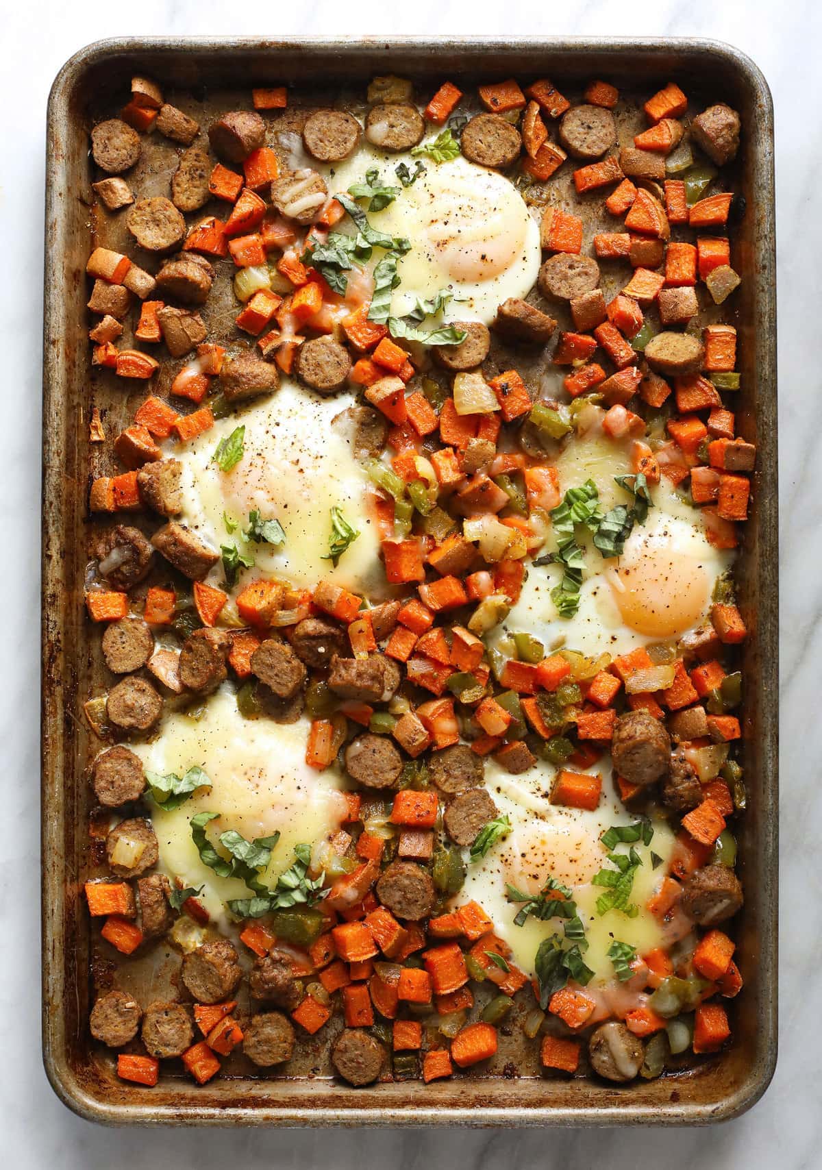 sweet potato hash on baking sheet with baked eggs