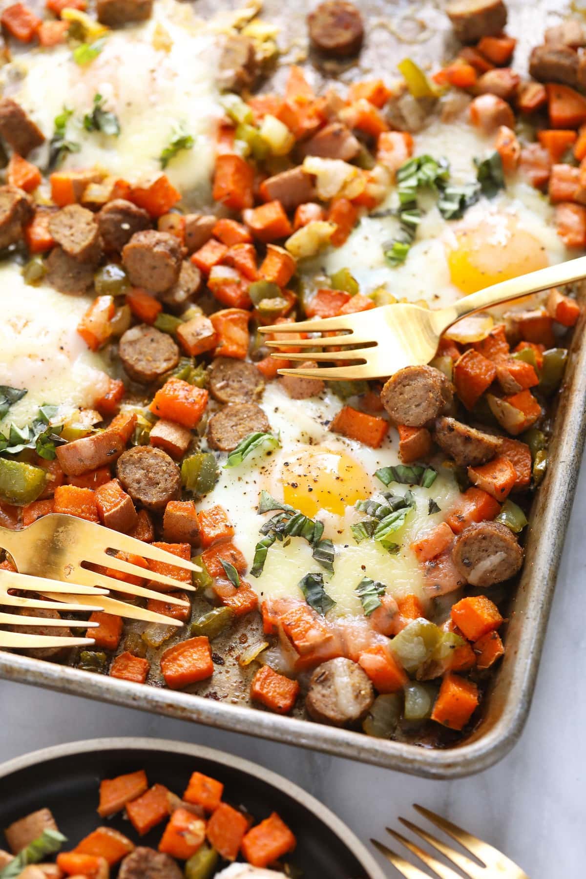 sweet potato hash on baking sheet with forks.