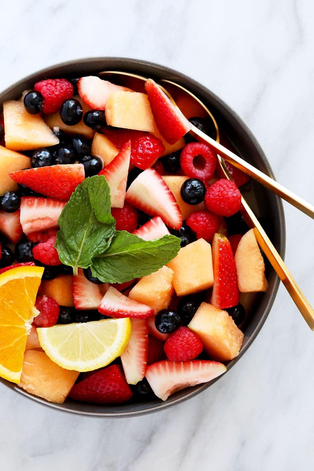 beautiful fruit salad recipe in a bowl topped with fresh mint